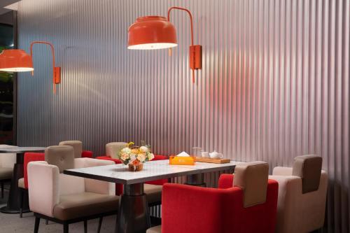 a dining room with a table and red chairs at From K Huan Kai Hotel Tiyuxi Metro Station in Guangzhou