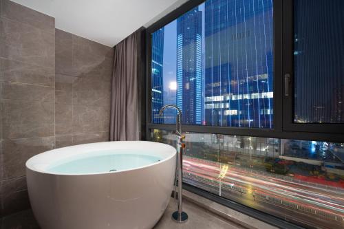 a bath tub in a bathroom with a window at From K Huan Kai Hotel Tiyuxi Metro Station- Free transportation during the Canton Fair in Guangzhou