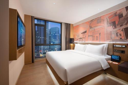 a bedroom with a large white bed and a large window at From K Huan Kai Hotel Tiyuxi Metro Station- Free transportation during the Canton Fair in Guangzhou
