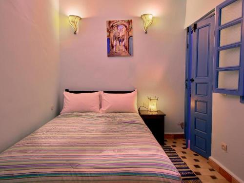 a bedroom with a bed and a blue door at Boujaad in Boujad