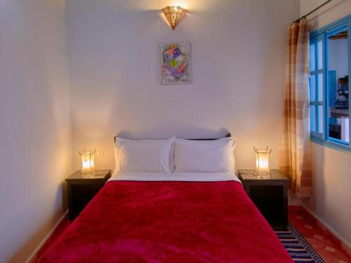 a bedroom with a red bed with two night stands at Boujaad in Boujad