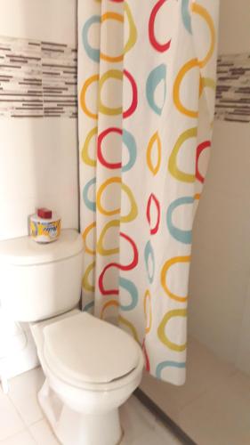 a bathroom with a toilet and a shower curtain at COVEÑAS PLAYAS TROPICALES in Coveñas