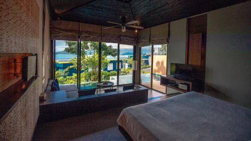 a bedroom with a bed and a large window at Sri Panwa Phuket Luxury Pool Villa Hotel - SHA Plus in Panwa Beach