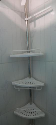 baño con estanterías blancas en una pared blanca en Aparta Estudio Rubí., en San Felipe de Puerto Plata