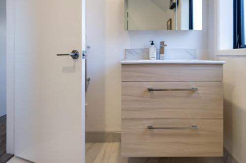 a bathroom with a sink and a vanity with a mirror at Explore Addington and CBD 1 bed w/carpark in Christchurch
