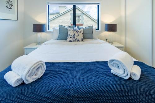 a bedroom with a large bed with towels on it at Explore Addington and CBD 1 bed w/carpark in Christchurch