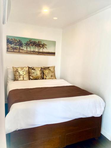 a bedroom with a large bed with palm trees on the wall at MAKATI Isabela Luxury in Manila