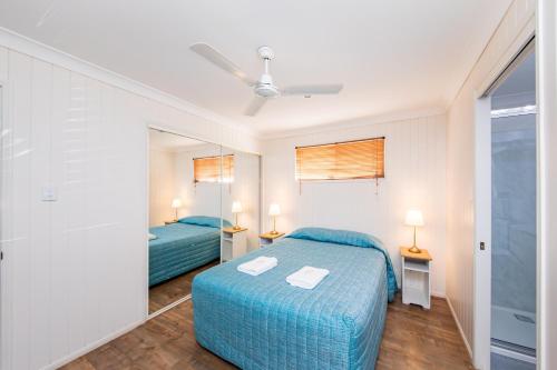 a bedroom with two beds and a mirror at Kingaroy Holiday Park in Kingaroy