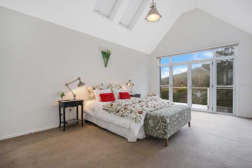 een witte slaapkamer met een bed en een groot raam bij Next to Bliss Luxury Guesthouse in Bright