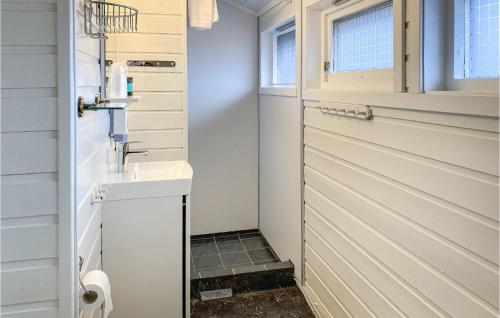 a small bathroom with a sink and a door at Awesome Home In Offersy With Sauna, Wifi And 3 Bedrooms in Offersøy