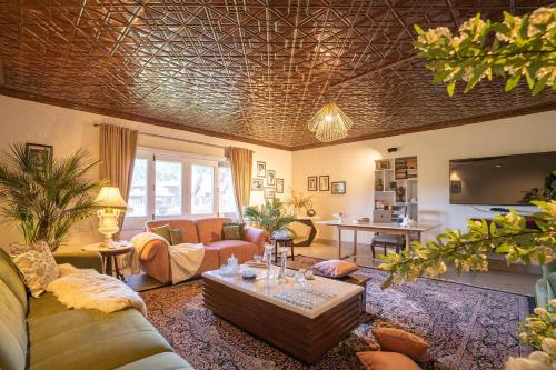 a living room with a couch and a table at StayVista at Waterside Estate in Srinagar