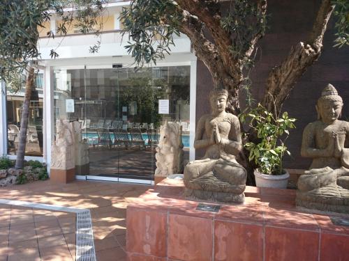 a group of statues sitting in front of a store at Hotel la Palmera & Spa in Lloret de Mar