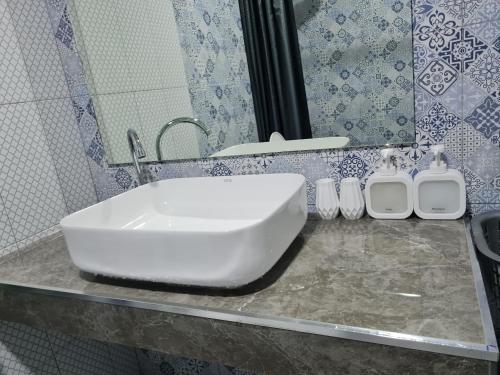 a bathroom with a white sink and a mirror at The Greenergy - NO LIFT - Book 48 hrs ahead - 4th floor in Hat Yai