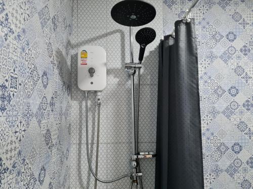 La salle de bains est pourvue d'une douche avec rideau de douche noir. dans l'établissement The Greenergy - NO ELEVATOR, à Hat Yai