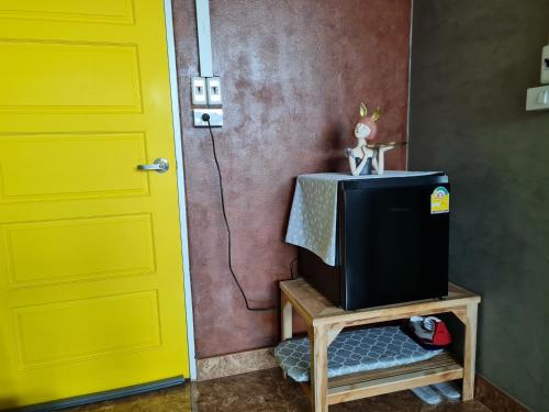 a yellow door and a tv next to a door at The Greenergy - NO LIFT - Book 48 hrs ahead - 4th floor in Hat Yai