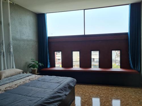 a bedroom with a bed and a large window at The Greenergy - NO LIFT - Book 48 hrs ahead - 4th floor in Hat Yai
