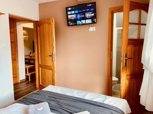a bedroom with a bed and a television on the wall at Cerla Korbielów in Korbielów