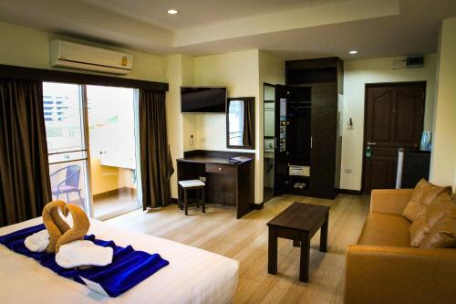 a hotel room with a bed and a living room at Sky Villa Hua Hin Guesthouse - Adults-Only in Hua Hin