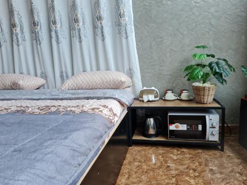 Un dormitorio con 2 camas y una mesa con radio. en The Greenergy - NO ELEVATOR en Hat Yai