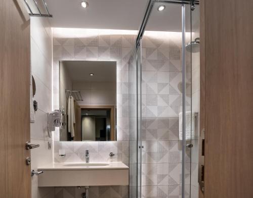 La salle de bains est pourvue d'un lavabo et d'une douche. dans l'établissement City Park INN - Art Studio, à Plovdiv