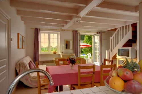 a kitchen and dining room with a table with a bowl of fruit at Gîtes de La Ferme De Kereven in Bénodet