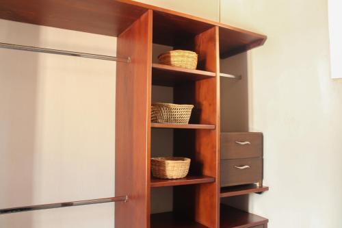 a wooden book shelf with baskets on it at Casa Gaitana - Alma Hotels in Santa Marta