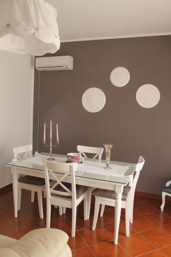 a dining room with a white table and chairs at B&B Home Sweet Home Rosolini in Rosolini