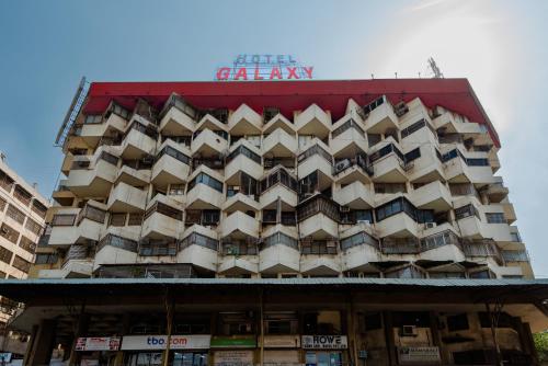 a large building with a sign on top of it at Hotel Galaxy Opp Surat Railway Station in Surat