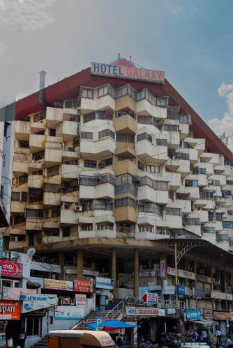 a large hotel building with a sign on it at Hotel Galaxy Opp Surat Railway Station in Surat