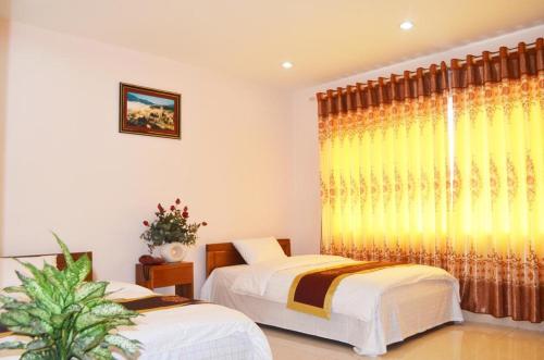 1 Schlafzimmer mit 2 Betten und einem Fenster in der Unterkunft HOTEL LAO CAI 33C CÁT LINH in Hanoi