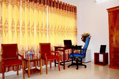 ein Esszimmer mit einem Tisch, Stühlen und einem gelben Vorhang in der Unterkunft HOTEL LAO CAI 33C CÁT LINH in Hanoi
