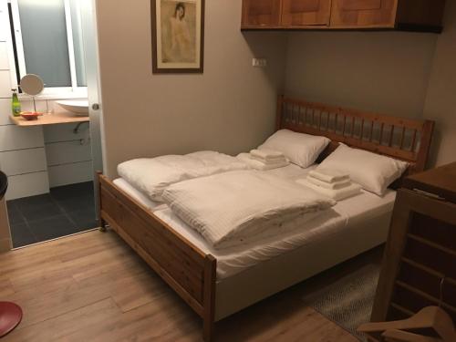 ein Bett mit weißer Bettwäsche und Kissen darauf in der Unterkunft Bialik St B&B room Bauhaus district Tel Aviv in Tel Aviv