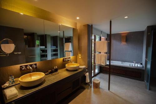 a bathroom with two sinks and a large mirror at Sri Panwa Phuket Luxury Pool Villa Hotel - SHA Plus in Panwa Beach