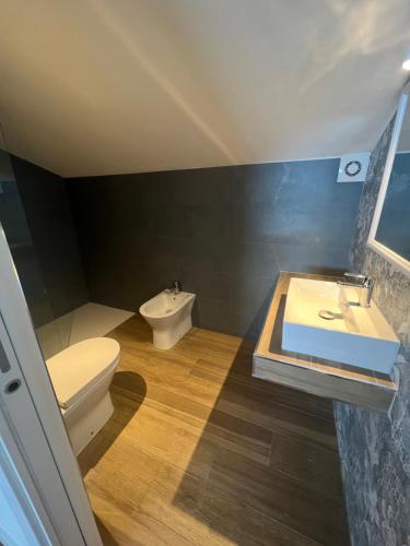 a bathroom with a white toilet and a sink at Villa Giannella in Orbetello