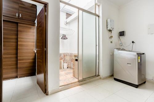 baño con puerta de cristal y lavadora en Apartamento turístico Medellín Laureles, By Family Rooms, en Medellín