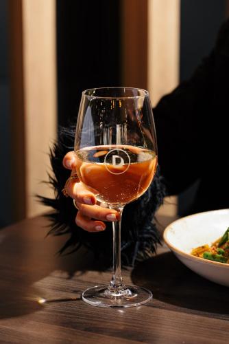 a person holding a glass of wine on a table at The Dingley Hotel in Dingley