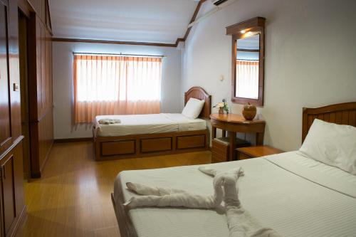 a room with two beds and a table and a window at Haadrin Resort in Haad Rin