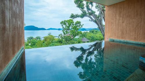 a swimming pool with a view of the water at Sri Panwa Phuket Luxury Pool Villa Hotel - SHA Plus in Panwa Beach