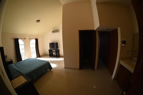 a bedroom with a bed and a bathroom with a television at 14 Comfortable suite for 2 people in Torreón