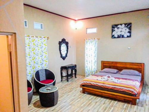 a bedroom with a bed and a table in it at G-Rima Home Stay in Labuan Bajo