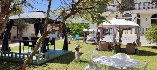 a gazebo and tables and chairs in a yard at Castle By The Sea in Artemida