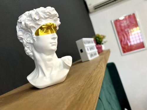 a white bust sitting on top of a wooden table at Acogedor y colorido estudio con cama King Size in Mérida