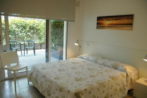 1 dormitorio con 1 cama y puerta corredera de cristal en Residence Isvico, en Lignano Sabbiadoro