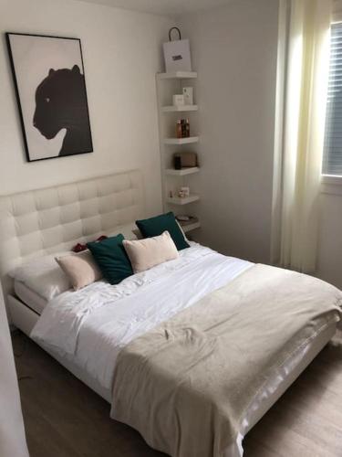 a bedroom with a large white bed with pillows at Villa Agde très calme in Agde