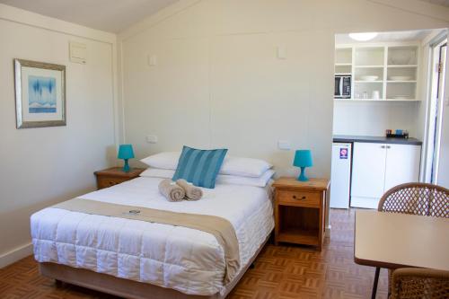 a bedroom with a bed with two towels on it at Seaspray Beach Holiday Park in Dongara