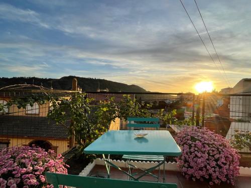 a blue table and chairs on a balcony with flowers at Casa rural VISTABLANCA en una sola planta con bonitas vistas y piscina - Junto a la capital y la Alhambra in Cenes de la Vega