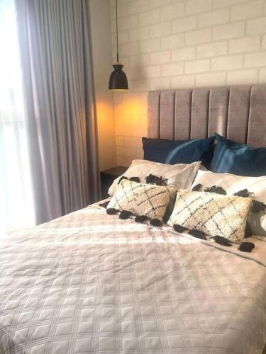 a bed with pillows on it in a bedroom at Apartamento nuevo de lujo in Barranquilla