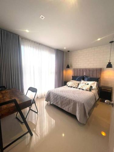 a bedroom with a bed and a table and a window at Apartamento nuevo de lujo in Barranquilla