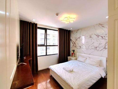 a bedroom with a white bed and a large window at Linh Homestay in Hanoi