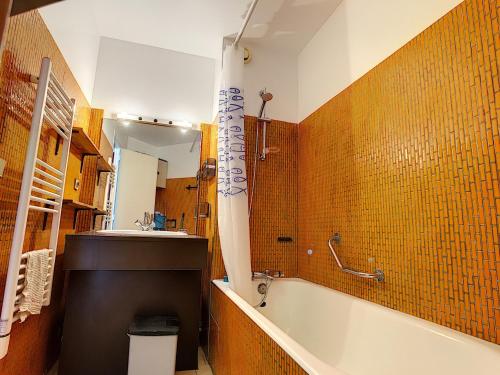une salle de bain avec une baignoire et un lavabo dans l'établissement Grand studio cabine accès plage parking privé - FR-1-715-16, à Mauguio